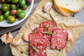 Delicious salami with olives, spices and rosemary. Selective focus.