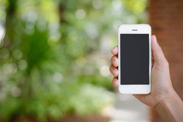 hand holding smartphone on abstract bokeh background