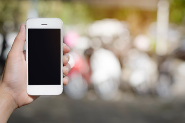 hand holding smartphone on abstract bokeh background