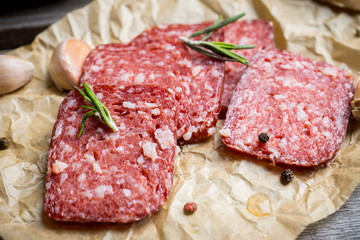 Delicious salami with olives, spices and rosemary. Selective focus.