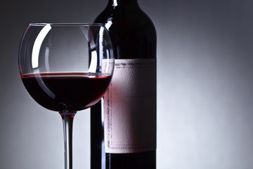 Bottle and glass of red wine .