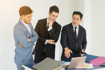 They are meeting new project so serius.Businessman looking at taplet and information in office.Businessman working at office with documents file on his desk.Meeting start up project