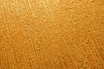 drops of gold paint on the wall texture