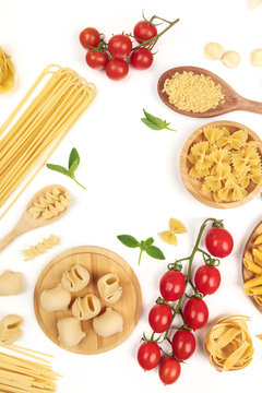 Overhead photo of different types of pasta with cherry tomatoes and basil on white with copy space