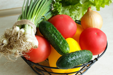 Organic vegetables in a basket on the kitchen table. Close-up.