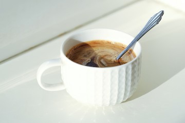 Cup of fresh coffee on a Sunny windowsill  