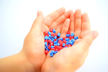 Child holding blue and red beads