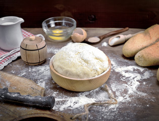 wheat yeast dough in a wooden bowl on a table
