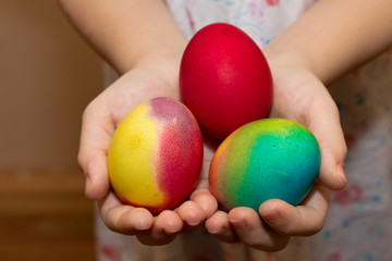 Fototapeta na wymiar Easter colorful eggs in the hands of a child. Made by hand at home.
