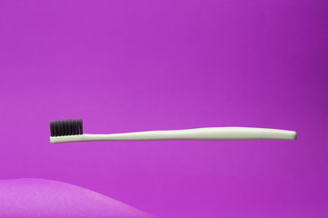 Floating toothbrush on pink background