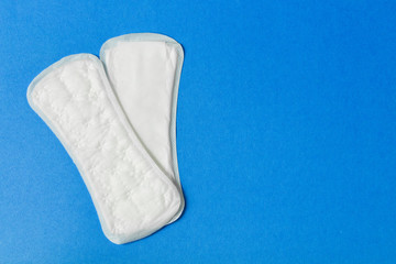 Women's sanitary pads on a blue background. Template advertising space . Copy space