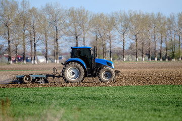 Tractor harrowing the land
