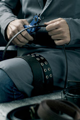 man making a hole in a belt with a leather punch