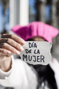 woman with pink hat and text womens day in spanish