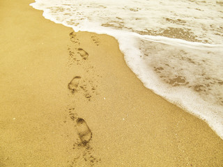 Abstract human footprints on sand beach.
View of the sand and water on the beach in Miami, Florida, USA.Travel vacation concept.