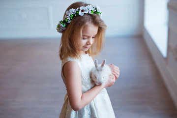 Cute little girl holding a bunny. Spring and easter portrait of beautiful child with rabbit.