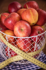 apple diet weight loss concept apples in basket with tape measure 