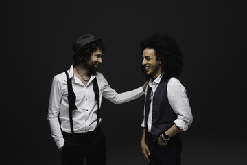 stylsih laughing men in white shirts on black