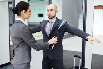 Fototapeta premium Female airport security using scanner to check one of passengers before flight