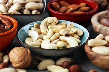 mixed nuts on grey background. Healthy food and snack. Walnut, pecan, almonds, hazelnuts and cashews.