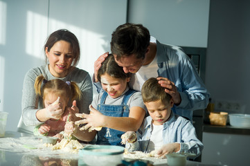 Large family prepares something of dough.