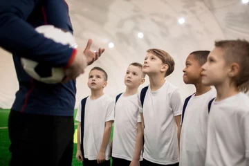 Foto op Plexiglas Row of cute boys listening to their soccer trainer explanation or comments © pressmaster