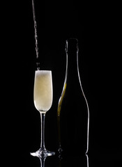 Silhouette champagne. Champagne pouring into glass on black background