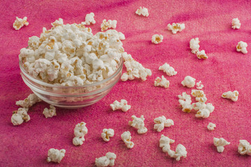 popcorn in a glass plate, on a pink background