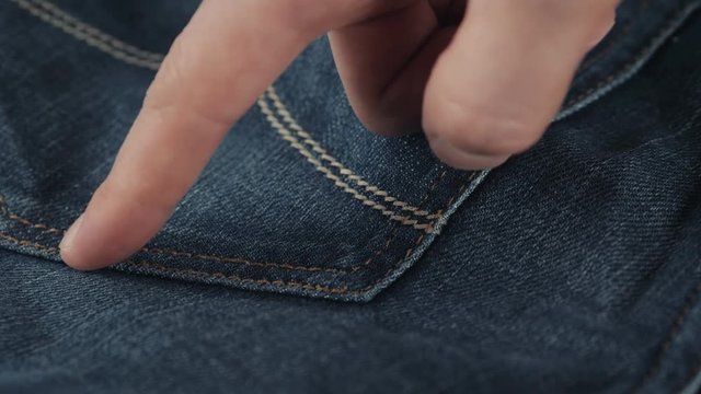 Close-up Of A Man's Hand touch The Blue Jeans pocket in shop store super close up