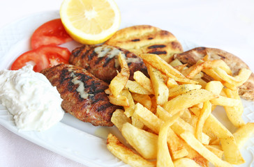 baked burgers with fried potatoes and greek tzatziki - traditional greek food