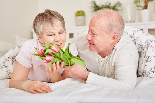 Senior überrascht seine Frau mit Blumen
