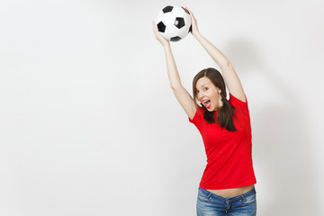 Active European young woman, two fun pony tails, football fan or player in red uniform catching classic soccer ball isolated on white background. Sport play football health, healthy lifestyle concept.