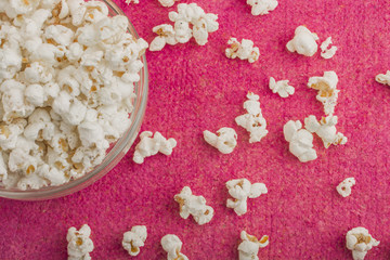 popcorn in a glass plate, on a pink background