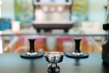 portafilter & tamper on counter bar at cafe. espresso tamping for coffee machine