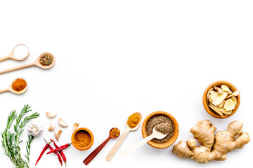 Seasoning background. Dry spices near ginger, garlic, rosemary, chili on white background top view copy space