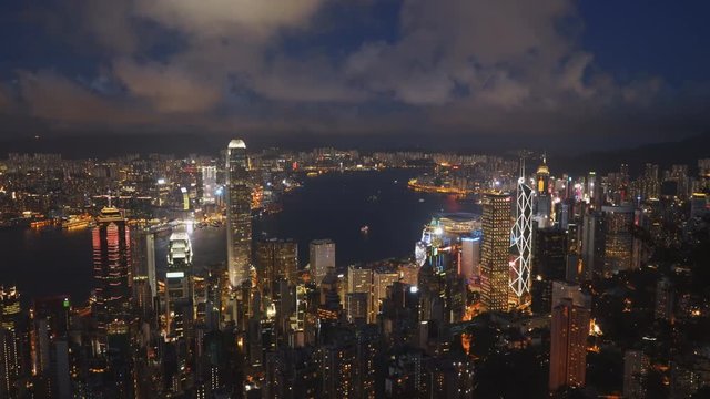 night panning shot of victoria harbour and hong kong island from the peak in hong kong, china
