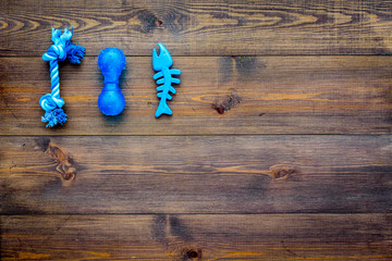 Toys for pets dog and cat. Rubber accessories on dark wooden background top view copy space