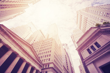 Looking up at the Wall Street buildings, color toned picture, New York City, USA.