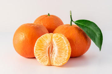 Whole tangerines or mandarines orange fruits and peeled segments isolated on white background