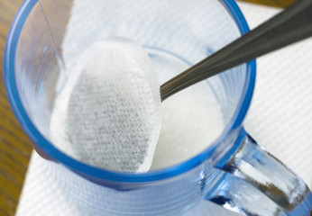 Tea bag in clear cup with sugar.  Close-up, selective focus.