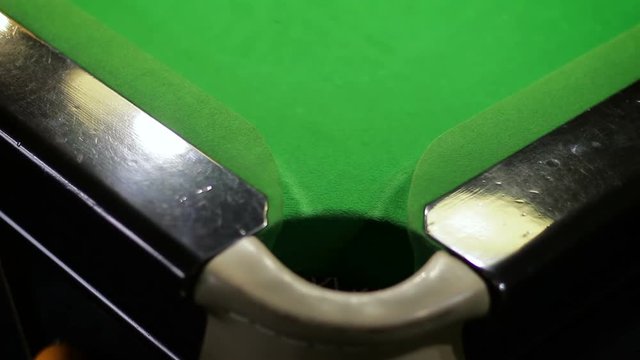 Fall of a red ball into a corner pocket on a snooker table
