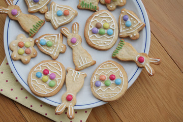 Easter glazed cookies in shape of egg, bunny, flower and bell on wooden background