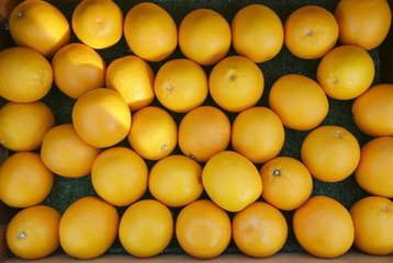 Top view of ripe tasty tangerines or orange fruits in wooden box