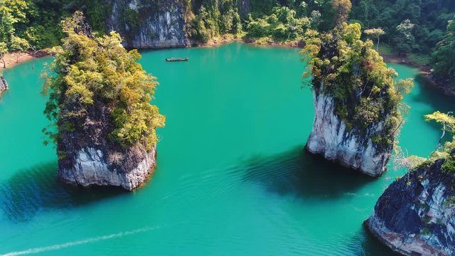 AERIAL. Beautiful top view of viridian Green Lake and traditional thai boat. Khao Sok national park in Surat Thani southern of Thailand. Similar to Guilin, China.