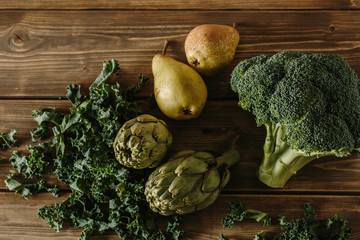 Fresh green vegetables on a rustic wooden table.