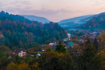 Landscape of Plastunka village in the valley and mountains with varicolored trees in autumn twilight, Sochi, Russia
