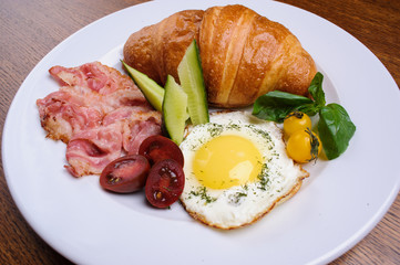 Fresh croissant with ham and salad