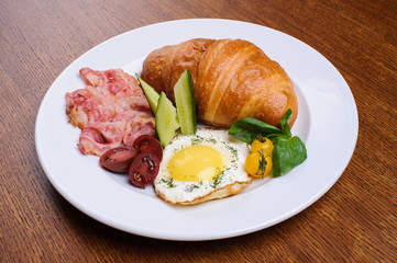 Fresh croissant with ham and salad