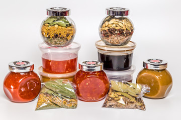 spices and sauces in jars on a white background