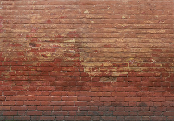 Red brown brick stone wall. Old grungy rough texture on facade of building. Horizontal wide brickwork fence.